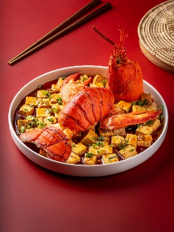 A bowl of food with a lobster tail

Description automatically generated