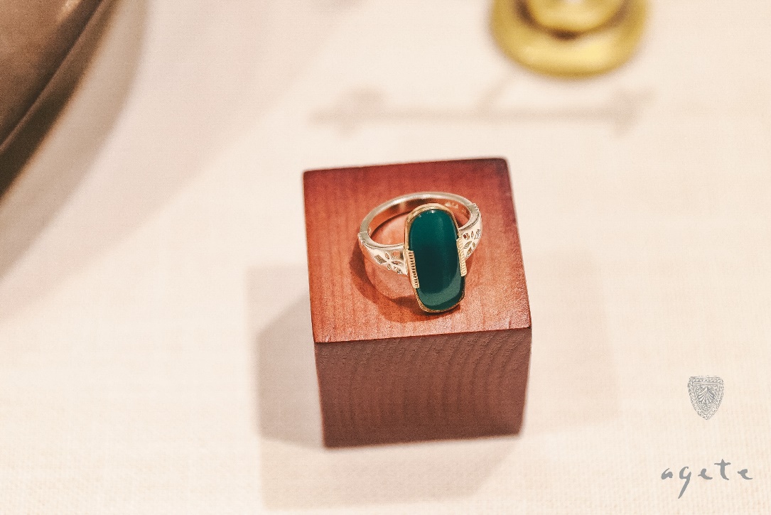 A ring on a wooden block

Description automatically generated