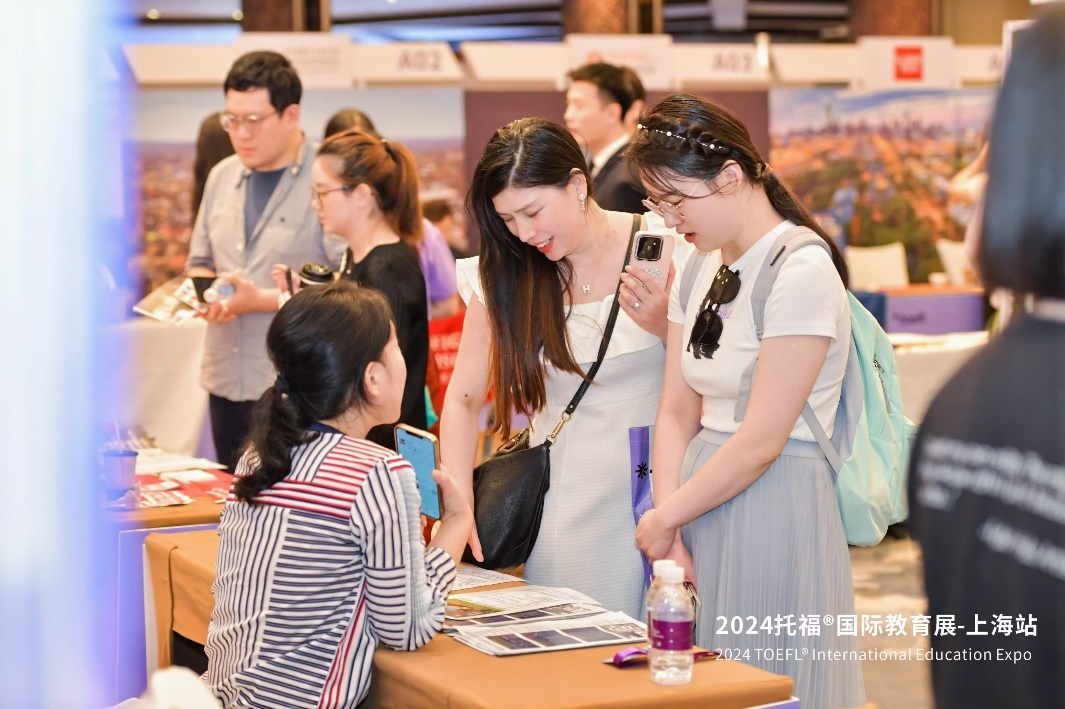 A group of women looking at a phone

Description automatically generated