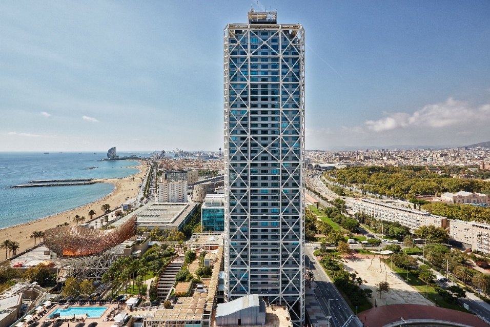 A tall building next to a body of water

Description automatically generated