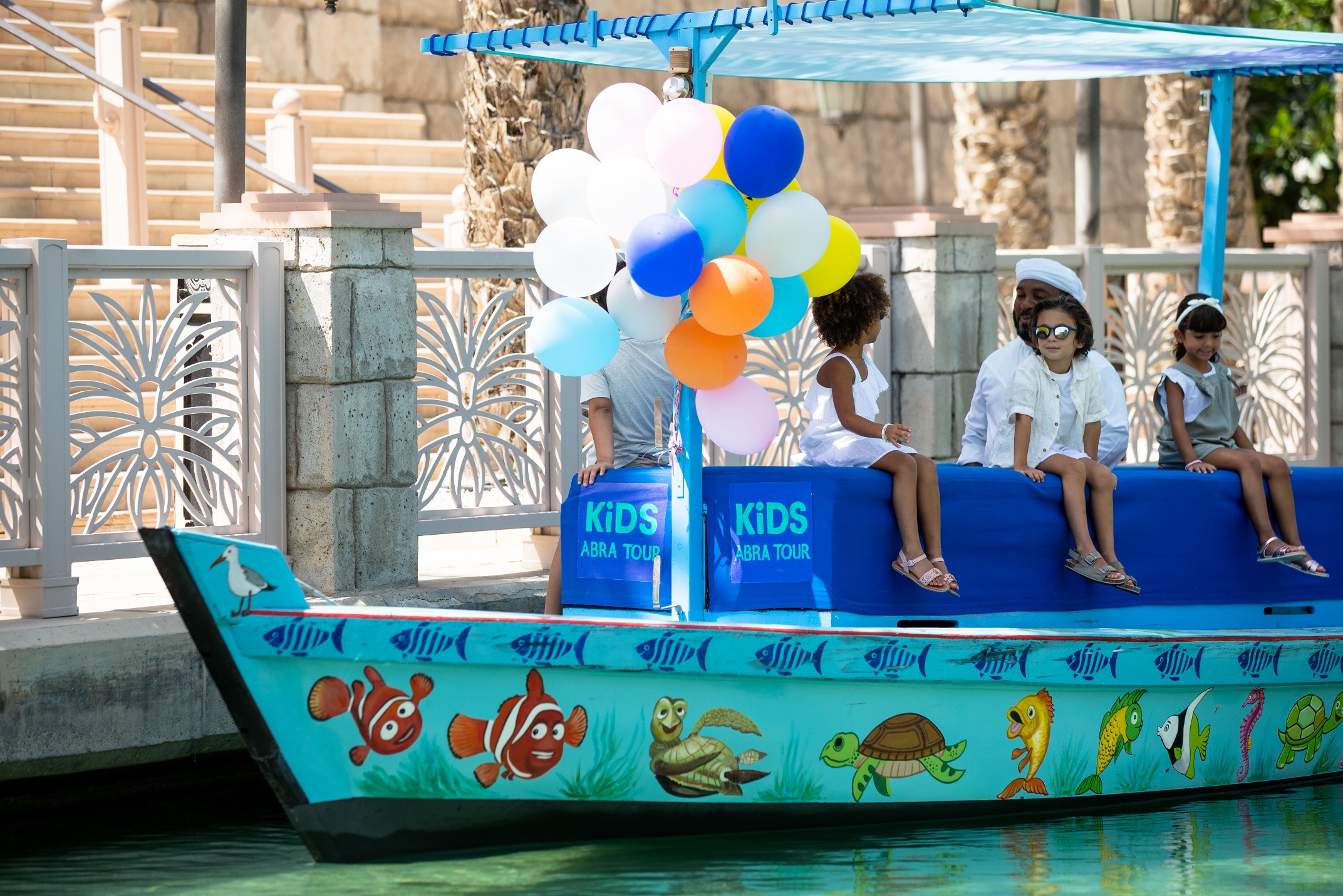 A group of kids on a boat with balloons AI-generated content may be incorrect.