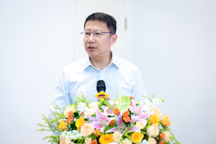 A person standing at a podium with a microphone and flowers AI-generated content may be incorrect.