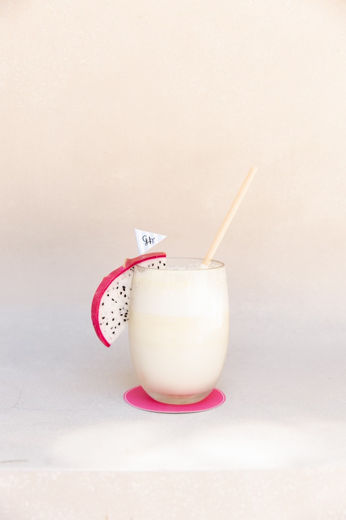 A glass of milk with a slice of dragon fruit on top AI-generated content may be incorrect.