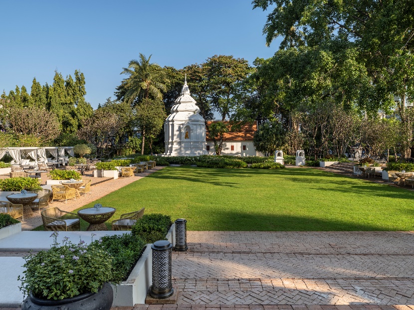 A white building with a green lawn and trees

AI-generated content may be incorrect.