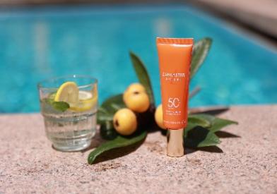A bottle of sunblock and a glass of water

Description automatically generated